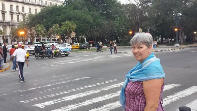 A busy crossing in Havana, with classic cars and a bicycle taxi.