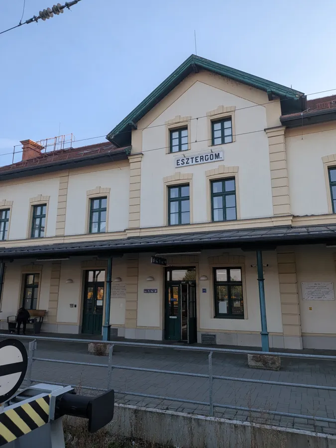 The cream-coloured Esztergom railway station building with green window frames